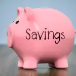 piggy bank labeled savings sitting on a desk representing a savings account